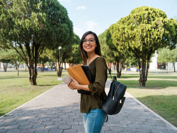 woman on collage campus holding books