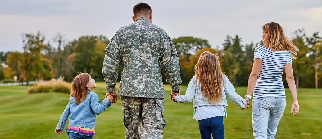 Veteran walking in a field with his family