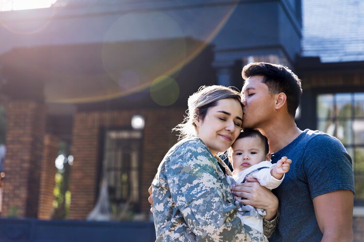 female Veterans with family in front of home