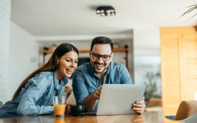 two people on a laptop smiling