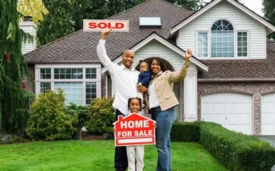 family in front yard of new home holding a sold sign