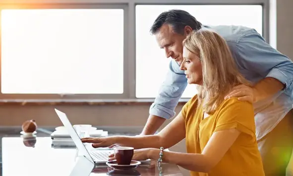 a couple at a computer looks at something
