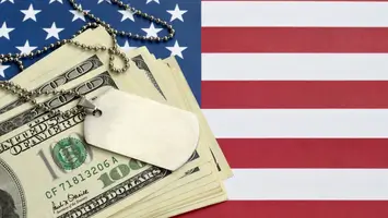 stack of money ontop of American flag