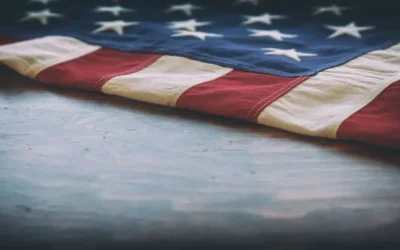 flag resting on veteran tombstone