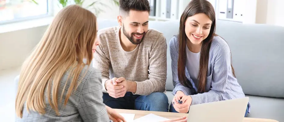 two people looking at a paper and about to sign.