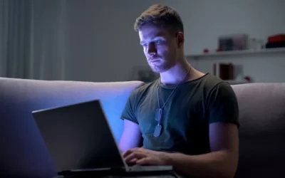 Military service member reviewing 2025 USAA pay dates and family budget on a laptop