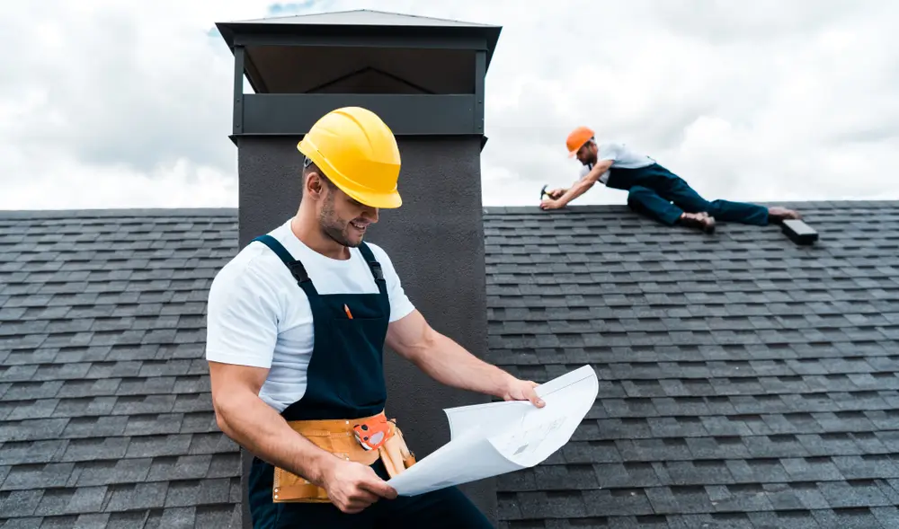 two guys fixing roof on a home