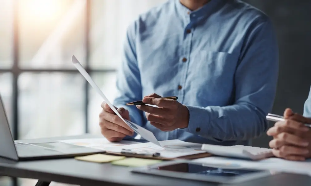 man in casual clothes reviewing documents at desk