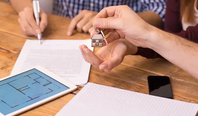 couple getting handing keys to new home by lender