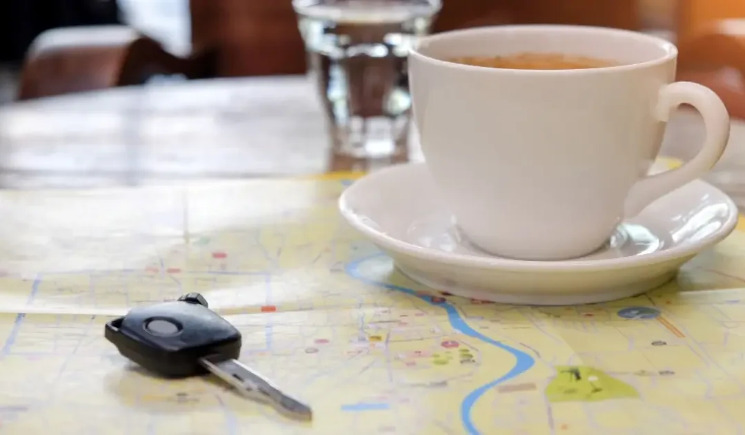 House key and military cover resting on a map and moving boxes, symbolizing the decision to use a VA loan to buy a home before a military PCS move.