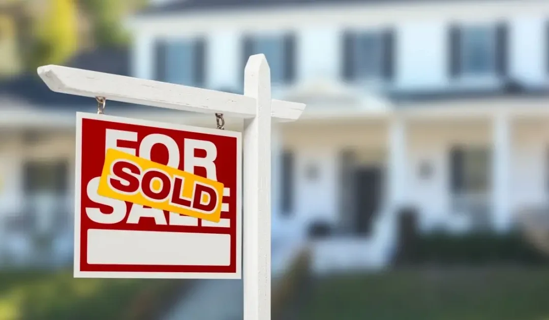 home with a sold sign in the front yard