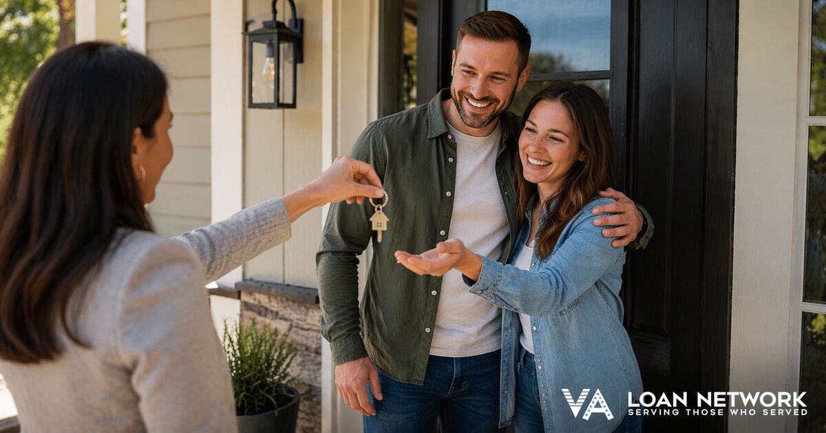 Couple holding house keys in front of new home