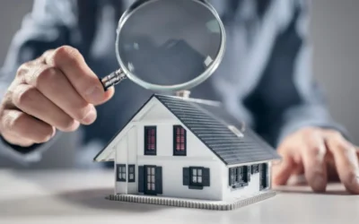 Magnifying glass over small house model during home appraisal review