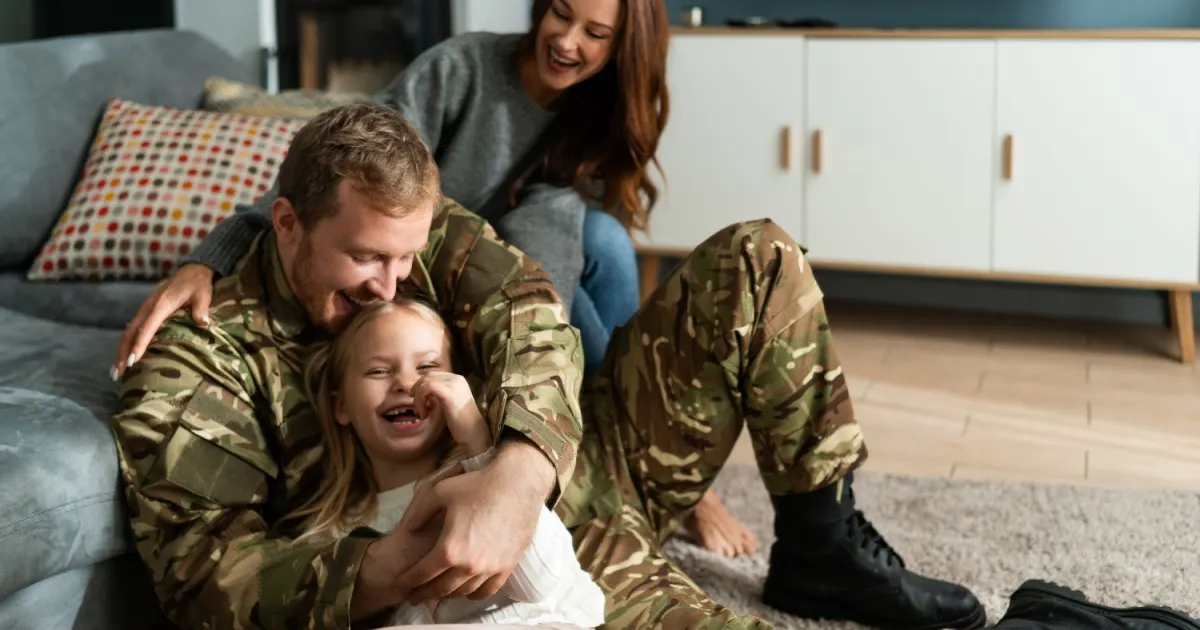 Military family hugging and smiling together at home